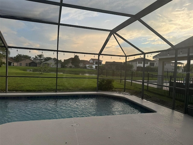 pool at dusk with glass enclosure and a yard