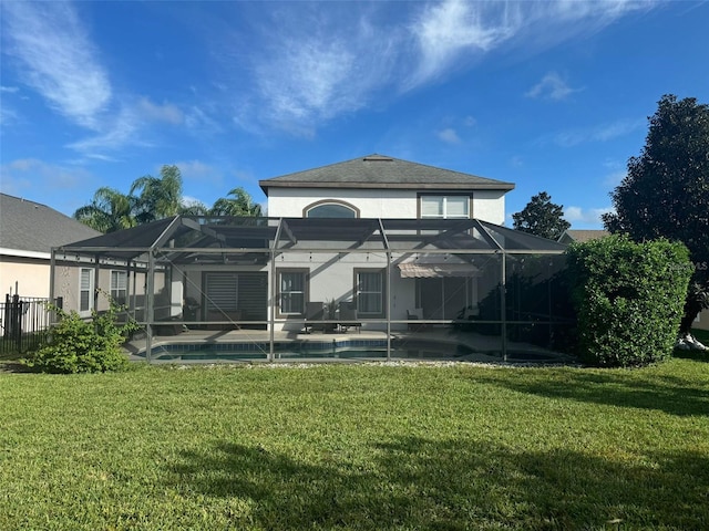 rear view of property with glass enclosure and a lawn