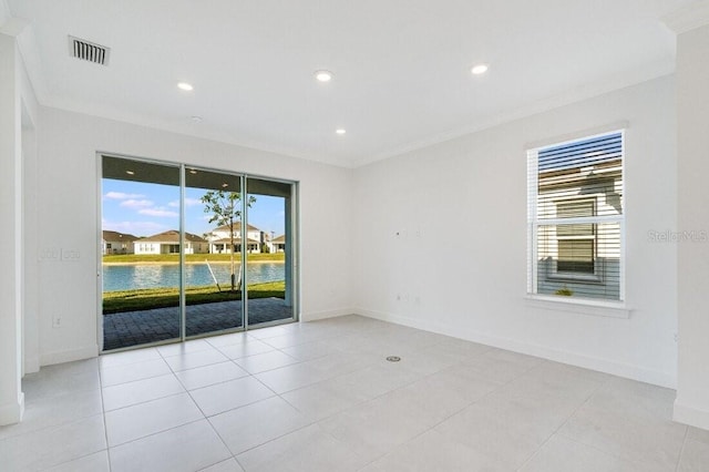 spare room with ornamental molding, a water view, and light tile patterned flooring