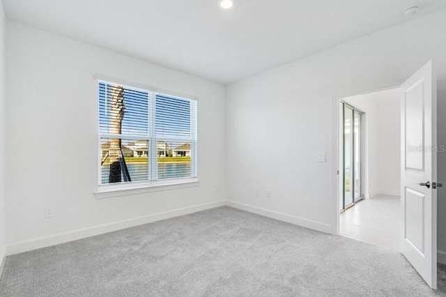 spare room featuring light colored carpet