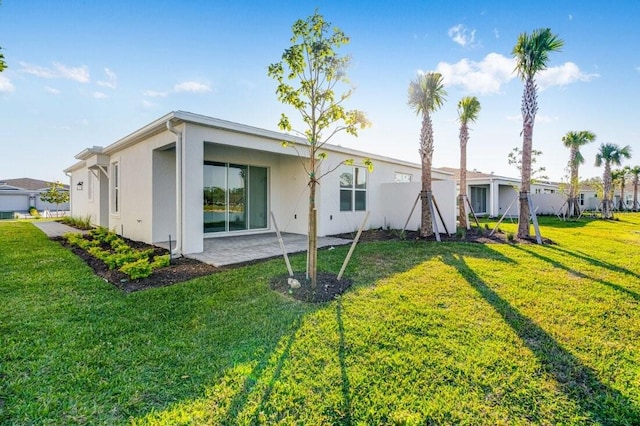 back of property with a patio area and a yard