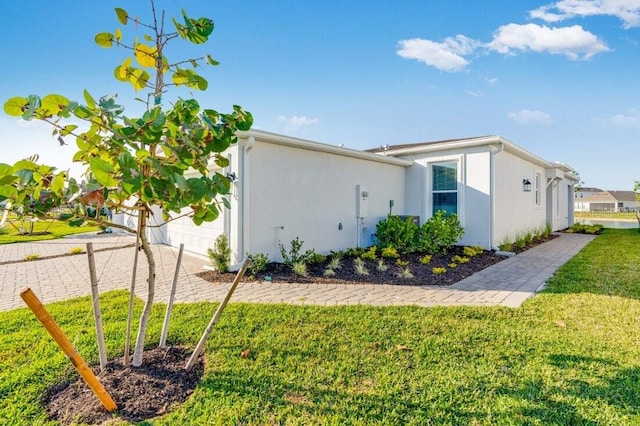 view of side of home with a yard and a garage