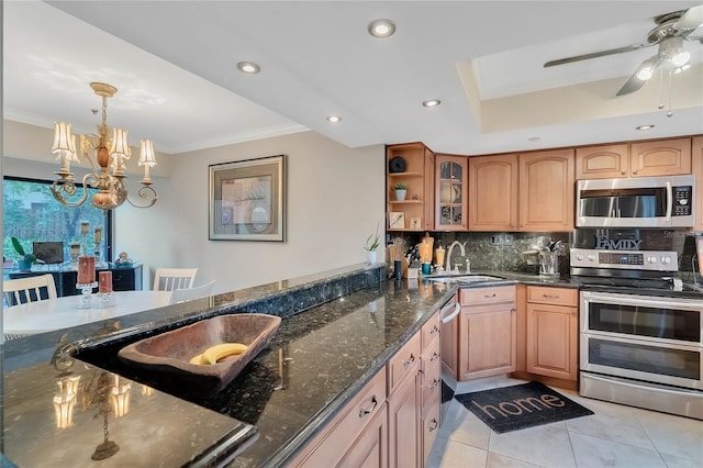 kitchen featuring dark stone counters, stainless steel appliances, sink, pendant lighting, and light tile patterned floors