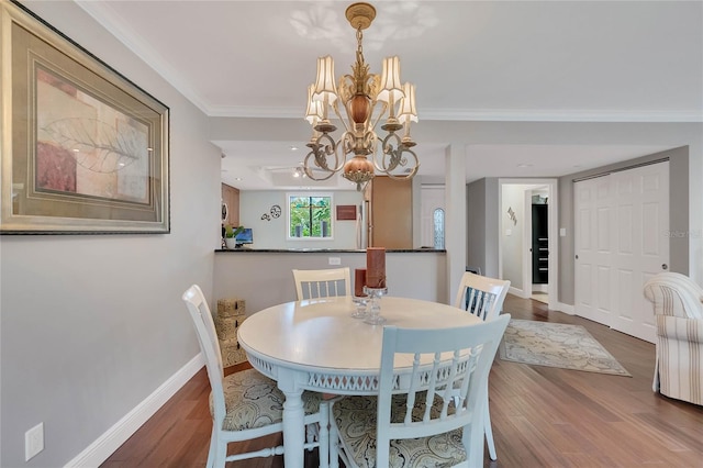 dining space featuring hardwood / wood-style flooring, an inviting chandelier, and ornamental molding