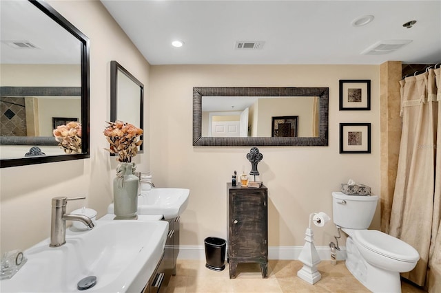 bathroom featuring tile patterned flooring, toilet, and sink