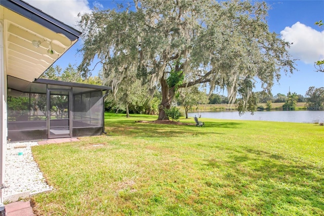 view of yard with a water view and a sunroom