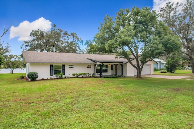 ranch-style home with a garage, stucco siding, driveway, and a front yard