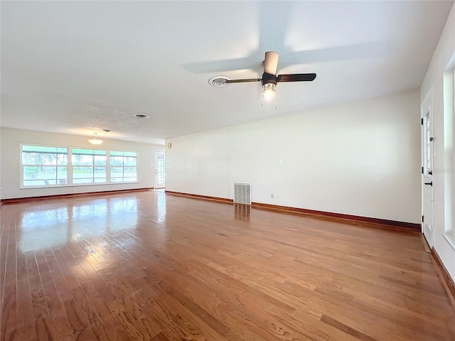 unfurnished room with visible vents, ceiling fan, baseboards, and wood finished floors