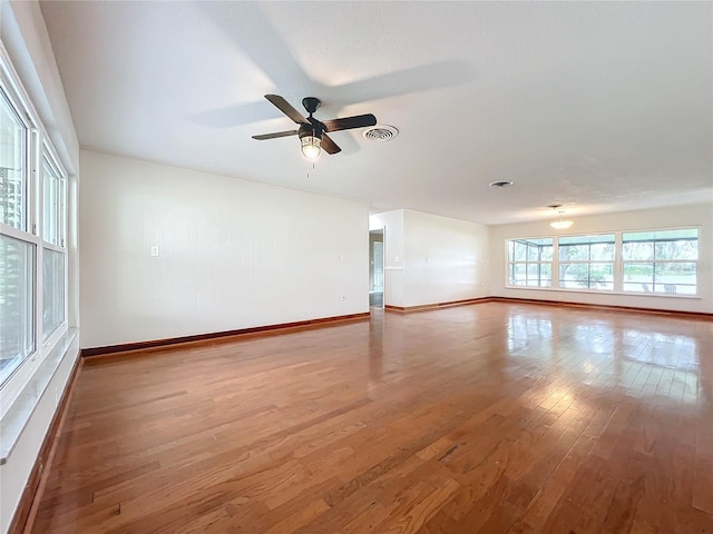 spare room with visible vents, baseboards, and wood finished floors