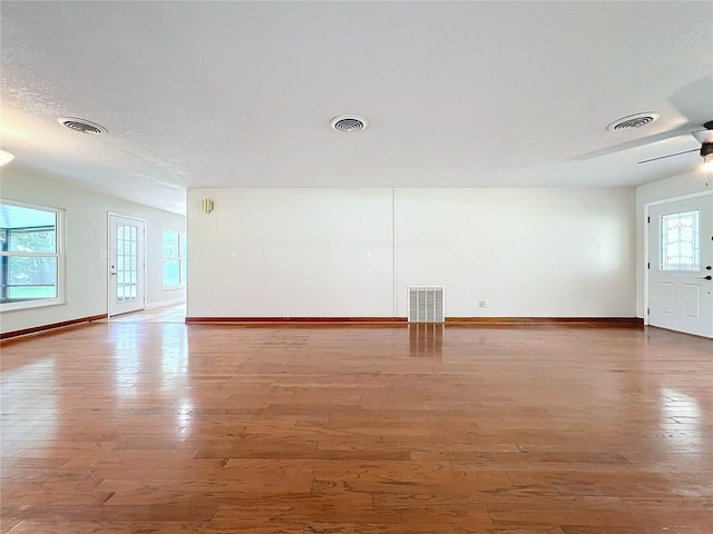 spare room with light wood-style floors and visible vents