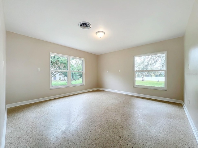 spare room with baseboards and visible vents