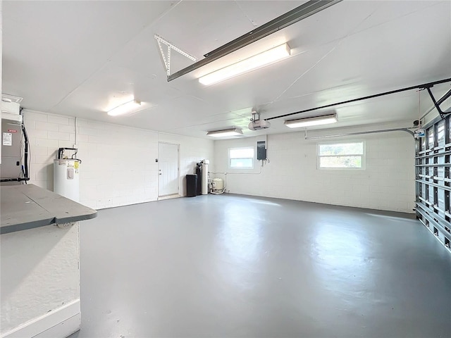 garage with concrete block wall, water heater, and a garage door opener