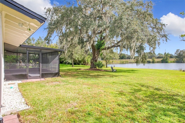 view of yard featuring a water view and a sunroom