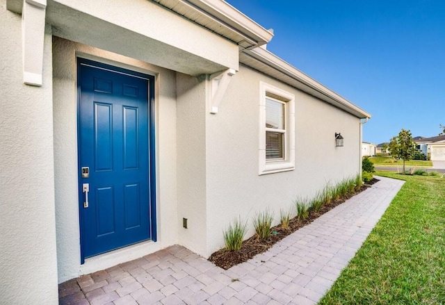 view of exterior entry with a yard