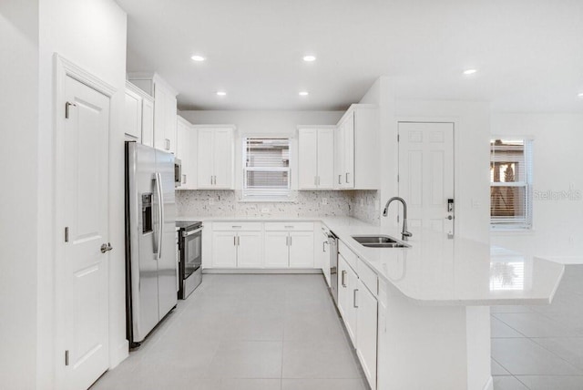 kitchen featuring sink, white cabinetry, stainless steel appliances, and plenty of natural light