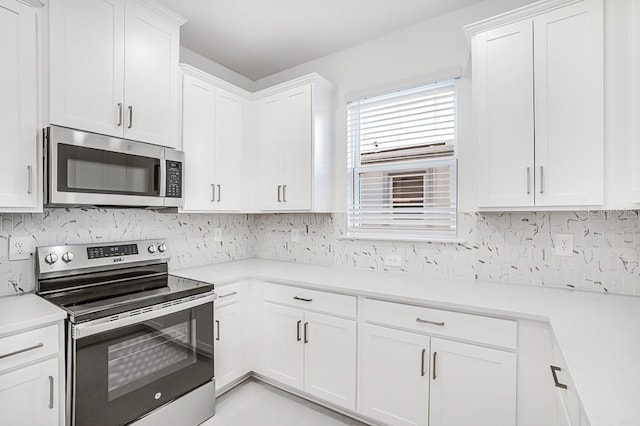 kitchen with white cabinetry, stainless steel appliances, and backsplash