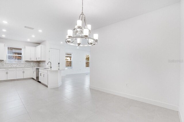 kitchen featuring decorative backsplash, pendant lighting, sink, white cabinetry, and kitchen peninsula