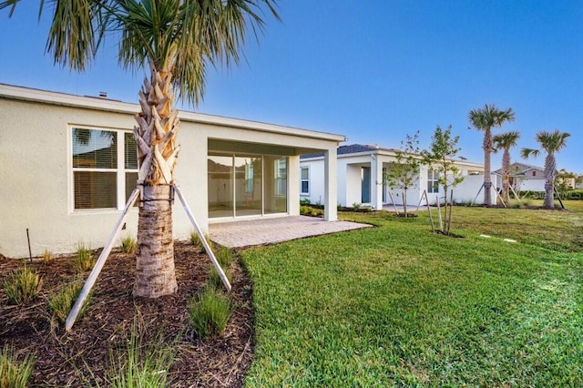 rear view of property with a yard and a patio area