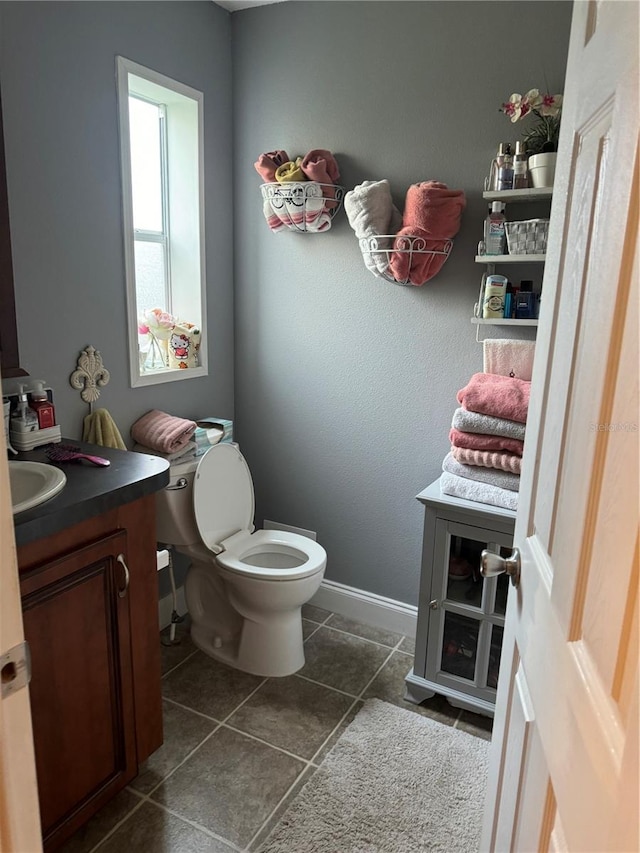 bathroom with tile patterned flooring, vanity, and toilet