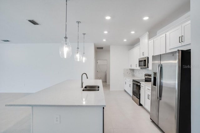 kitchen with sink, white cabinets, tasteful backsplash, pendant lighting, and appliances with stainless steel finishes