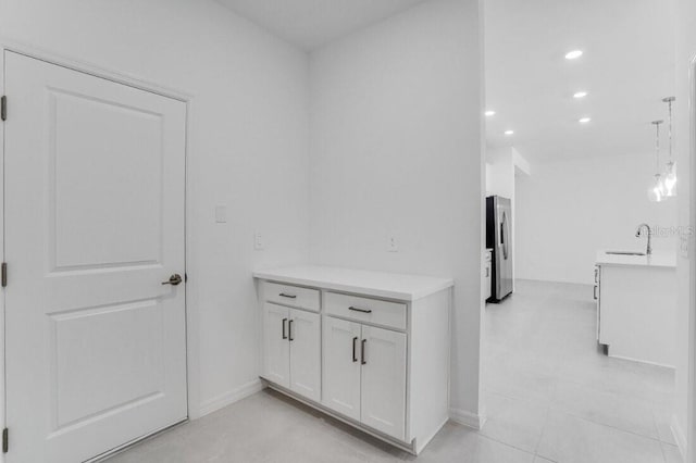 corridor featuring light tile patterned flooring and sink