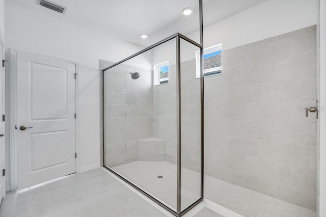 bathroom featuring tiled shower and tile patterned flooring