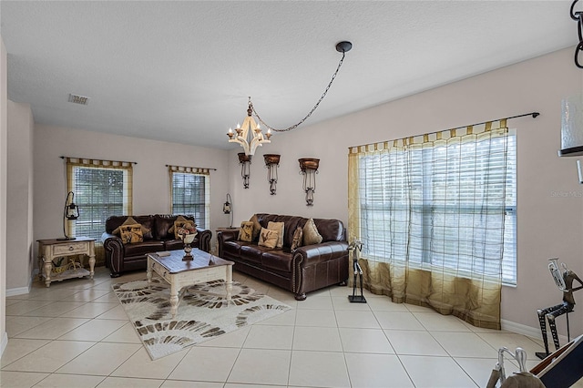 living room with plenty of natural light, light tile patterned flooring, and an inviting chandelier