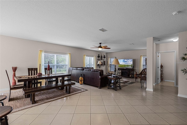 tiled living room with ceiling fan and a textured ceiling