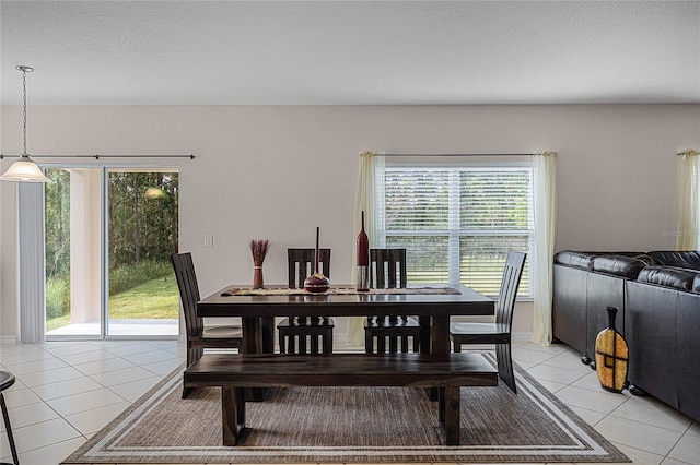 dining area featuring plenty of natural light, light tile patterned floors, and a textured ceiling