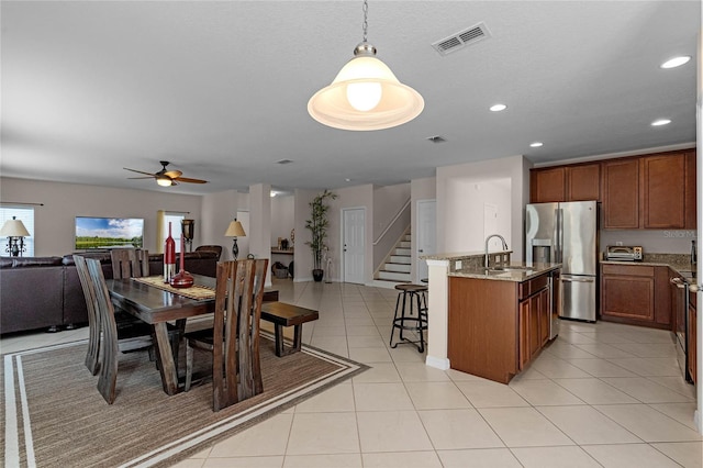 dining room featuring light tile patterned floors, ceiling fan, and sink