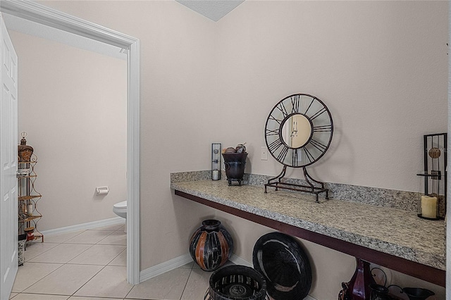 interior space featuring tile patterned flooring and toilet