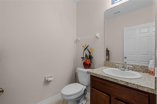 bathroom featuring tile patterned flooring, vanity, and toilet