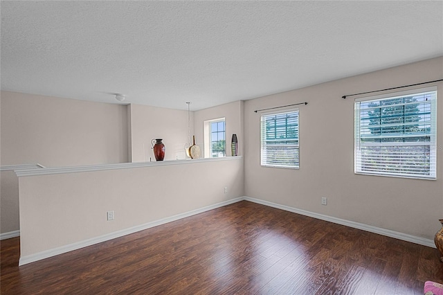 unfurnished room with dark hardwood / wood-style floors and a textured ceiling