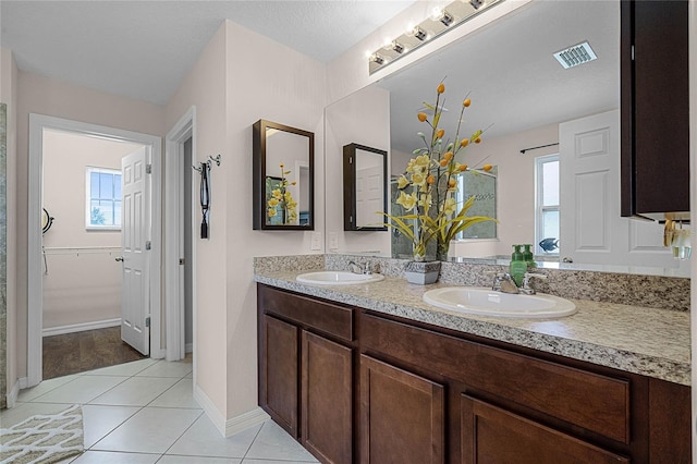 bathroom featuring tile patterned flooring, plenty of natural light, a textured ceiling, and vanity