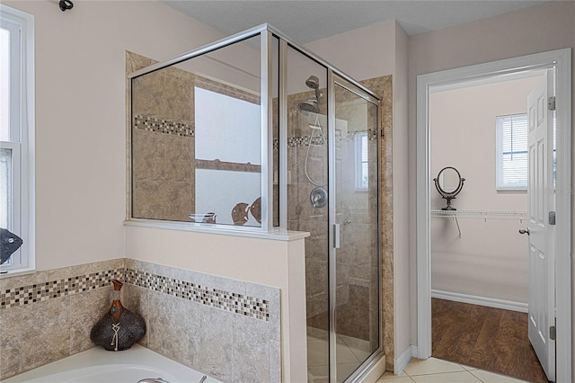 bathroom featuring plus walk in shower and hardwood / wood-style flooring