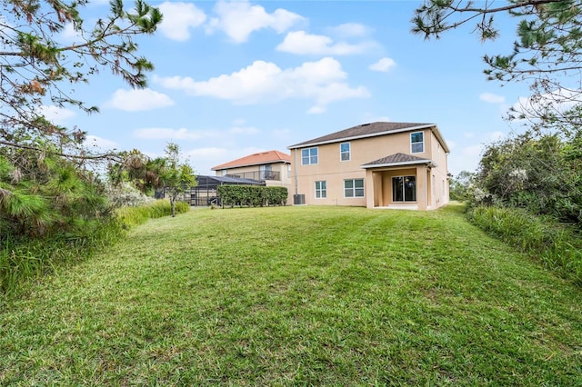 back of property featuring a lawn and central air condition unit