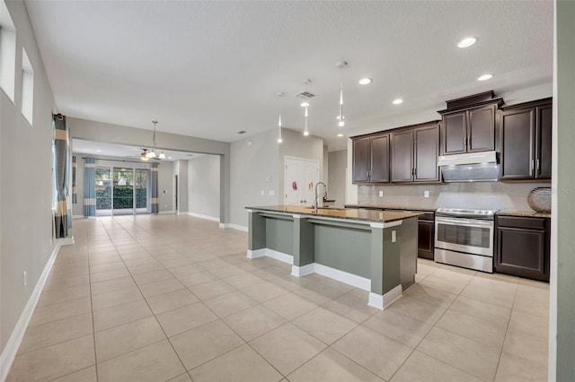 kitchen featuring tasteful backsplash, a center island with sink, sink, stainless steel electric range oven, and light stone countertops