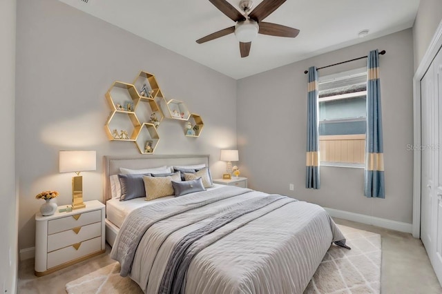 carpeted bedroom with ceiling fan and a closet