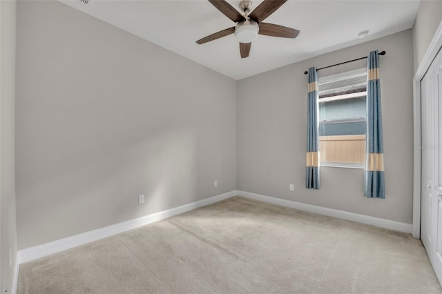 carpeted spare room featuring ceiling fan