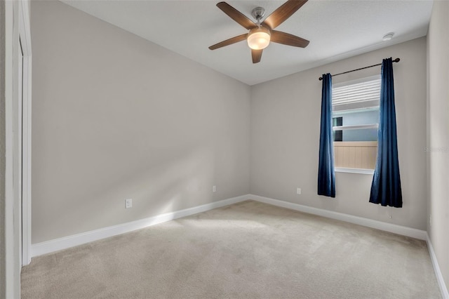 spare room with ceiling fan and light colored carpet