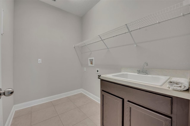 washroom with sink, washer hookup, light tile patterned floors, hookup for an electric dryer, and cabinets