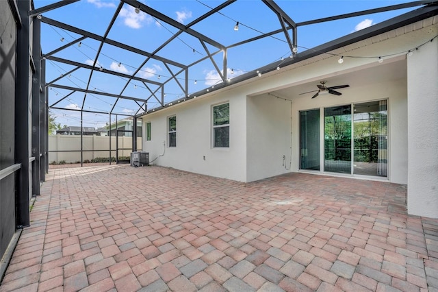 view of patio with glass enclosure, cooling unit, and ceiling fan