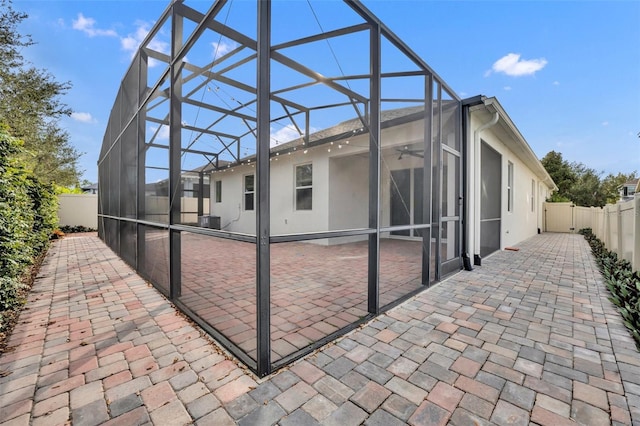 view of patio / terrace featuring glass enclosure and ceiling fan