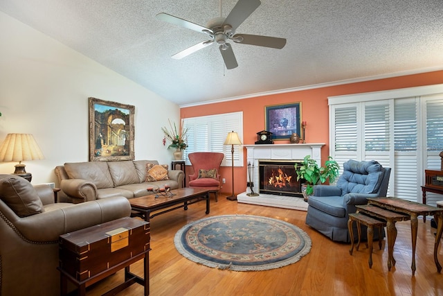 living room featuring lofted ceiling, ceiling fan, hardwood / wood-style floors, and a textured ceiling