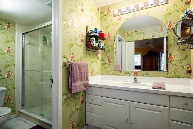 bathroom featuring tile patterned floors, vanity, an enclosed shower, and toilet