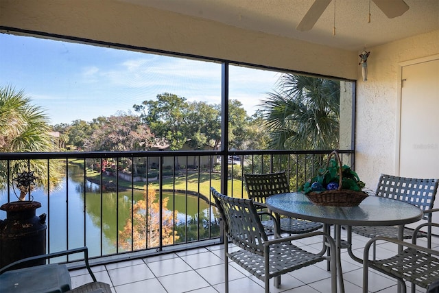 balcony featuring ceiling fan and a water view