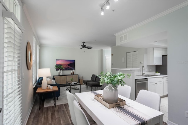 dining space featuring hardwood / wood-style floors, ceiling fan, ornamental molding, and sink