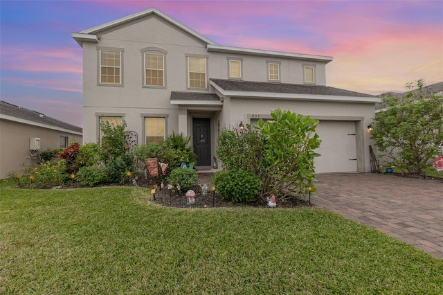 front of property featuring a lawn and a garage