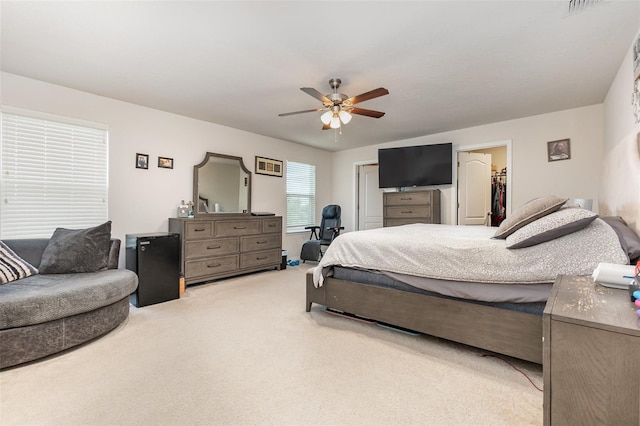 carpeted bedroom featuring ceiling fan, a closet, and a spacious closet