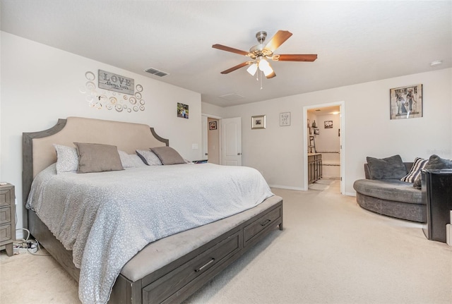 carpeted bedroom with ensuite bathroom and ceiling fan